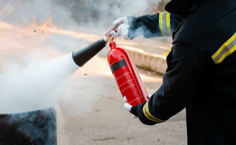 a firefighter using a fire extinguisher